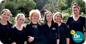 Photograph of Auckland Zoo staff, lined up and smiling in the sun.